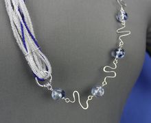 Unique asymmetrical glass bead necklace with wirework links, blue, clear, and silver