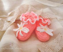 Knitted pink baby-shoes with a flower