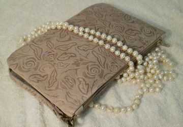 A beige leather clutch with floral design