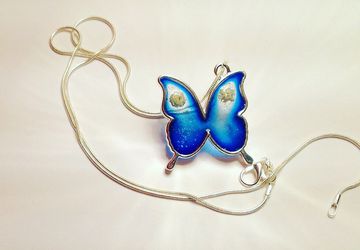 Silver necklace with pendant. Blu resin butterfly and flowers