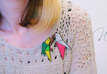 Origami style parrot brooch made from polymer clay in green and yellow tones